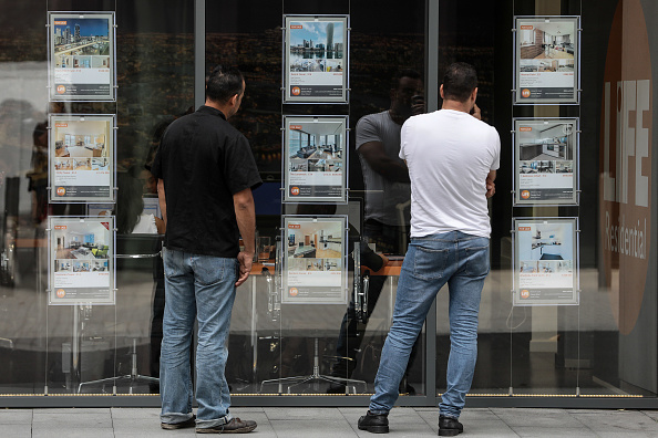Peatones revisan la oferta de propiedades inmobiliarias