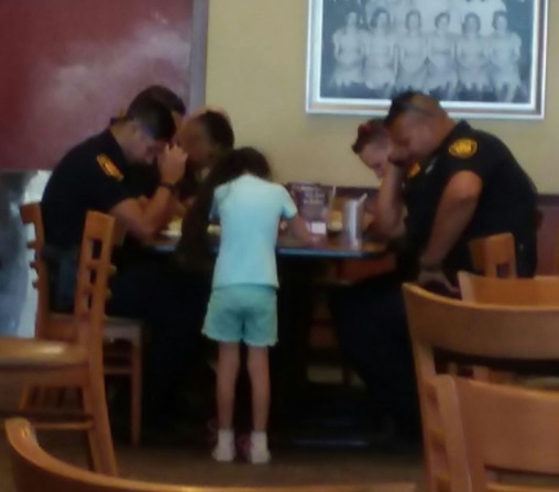 Una niña reza con agentes de policía de San Antonio, Texas (Foto: Facebook Martha Bosquez)