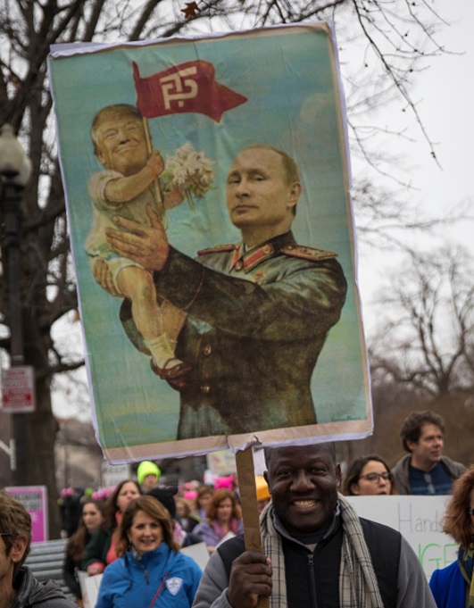 Una pancarta del presidente Putin que sostiene a un bebé con una imagen sobrepuesta de Donald Trump durante una protesta en EU (Getty Images)