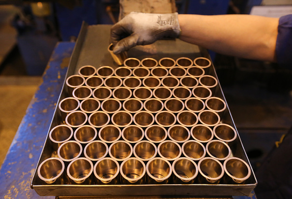 Un trabajador prepara una bandeja de anillos de cobre