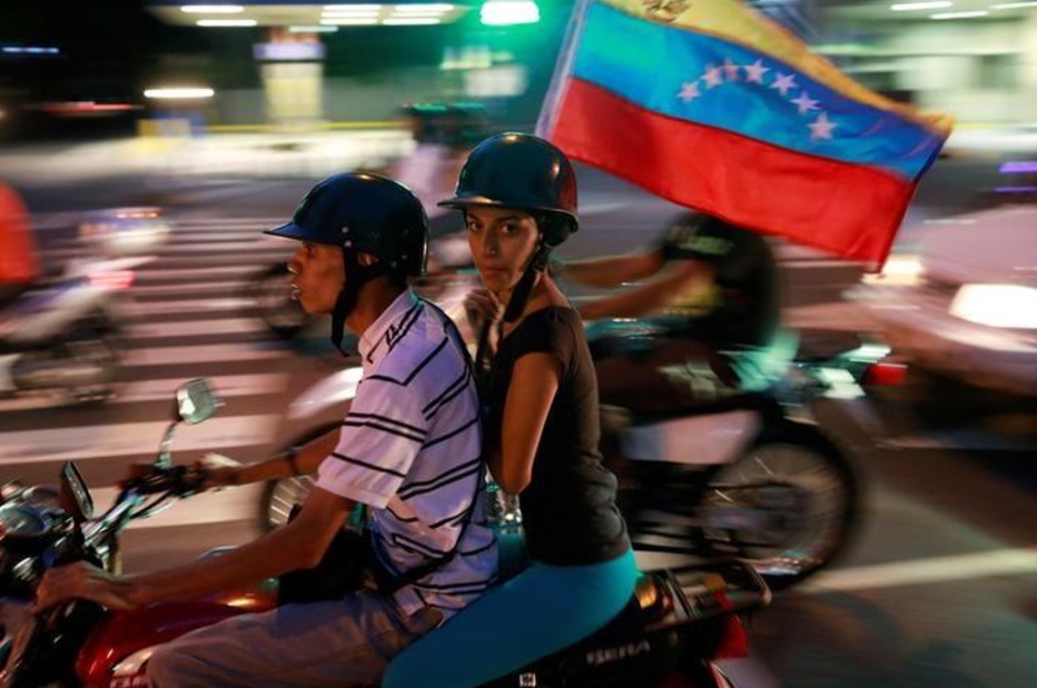 Partidarios de la oposición montan en una motocicleta después de un plebiscito no oficial contra el gobierno del presidente Nicolás Maduro (Reuters)