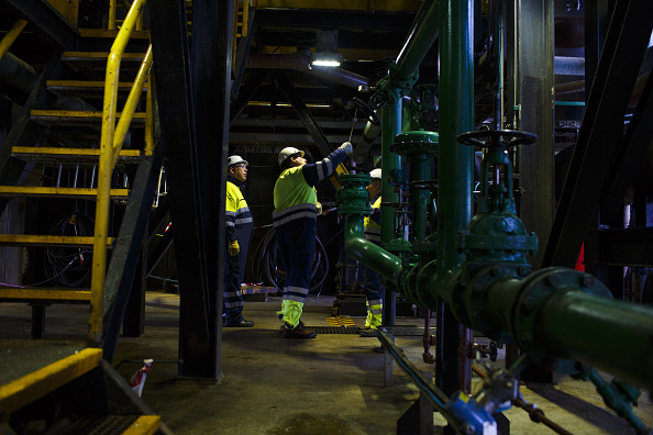 Ingenieros controlan válvulas de tubería en plataforma petrolera