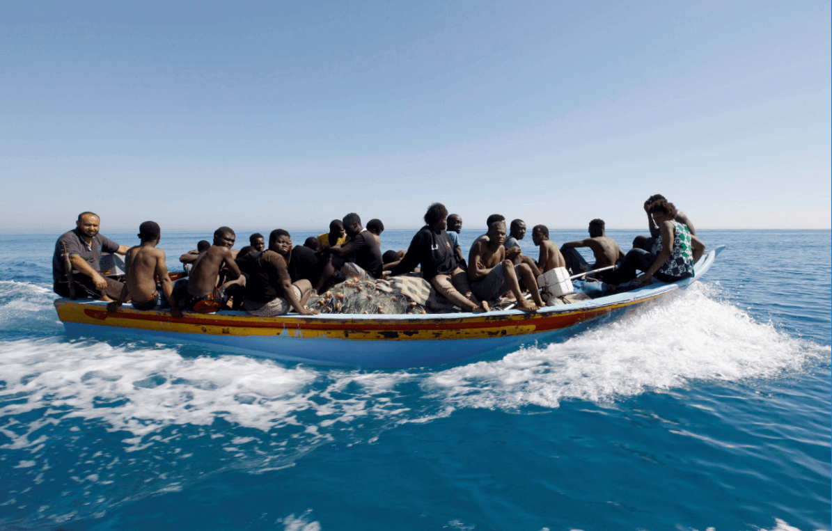 Migrantes viajan en un bote luego de ser rescatados