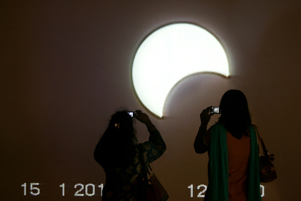 dos personas ven como evoluciona un eclipse