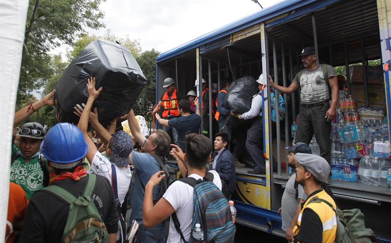 Mexicanos ayudan en la repartición de víveres. (EFE)