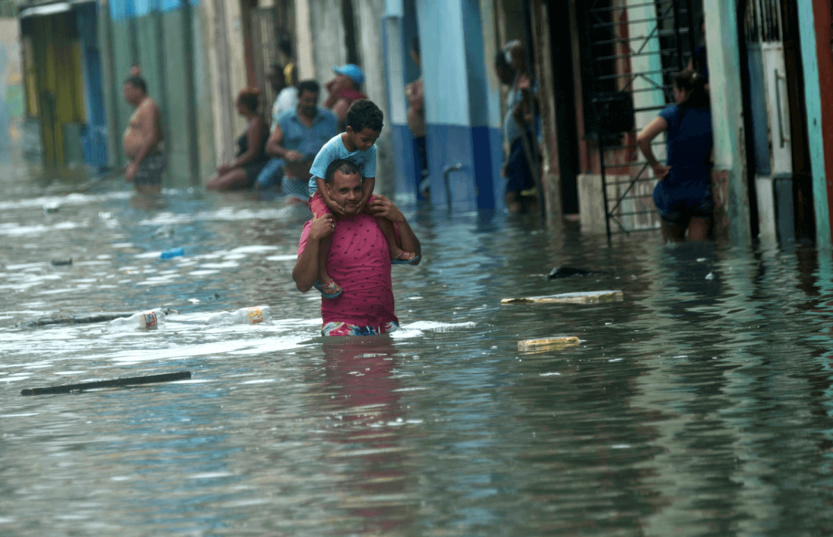 Un hombre carga a un niño durante las inundaciones en Cuba, provocadas por el huracán 'Irma'