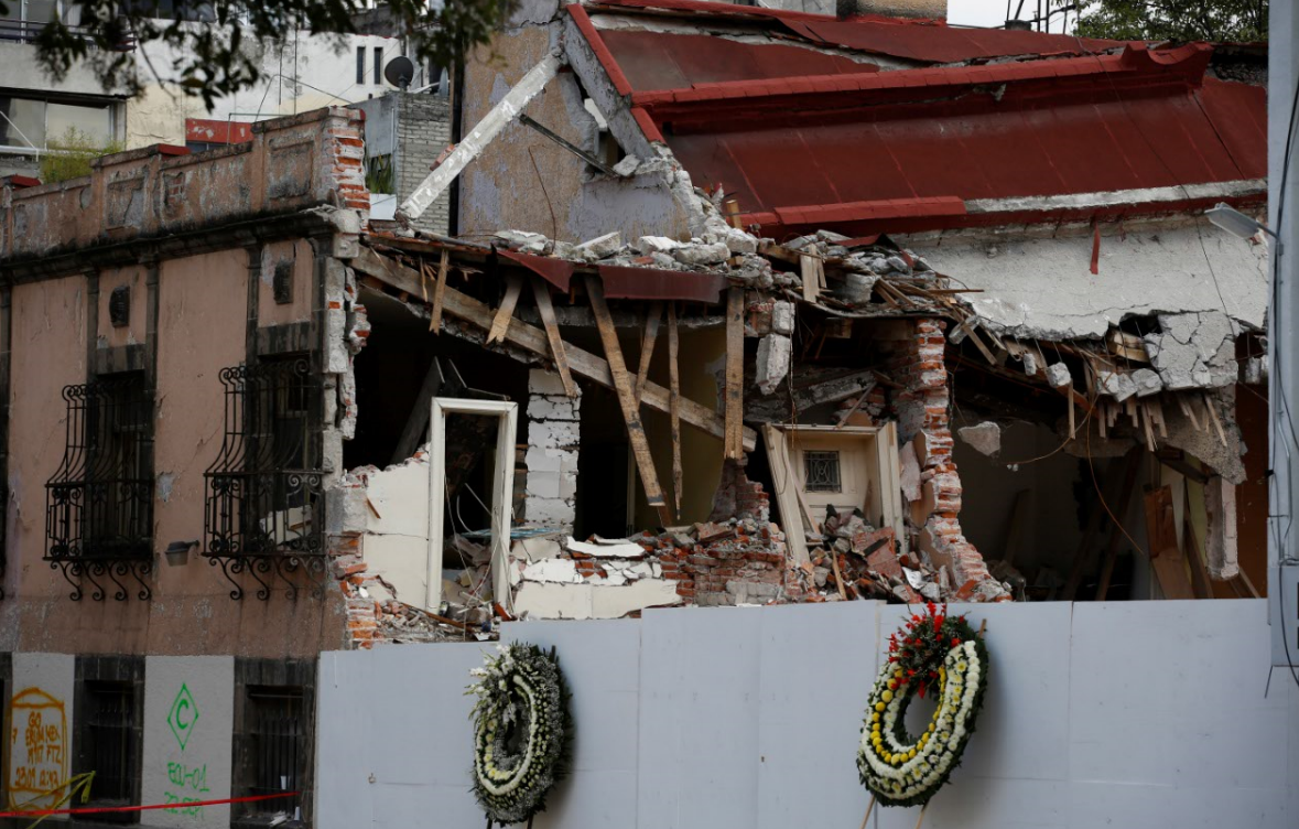 Coronas fúnebres frente a escombros del laboratorio colapsado tras sismo del 19S