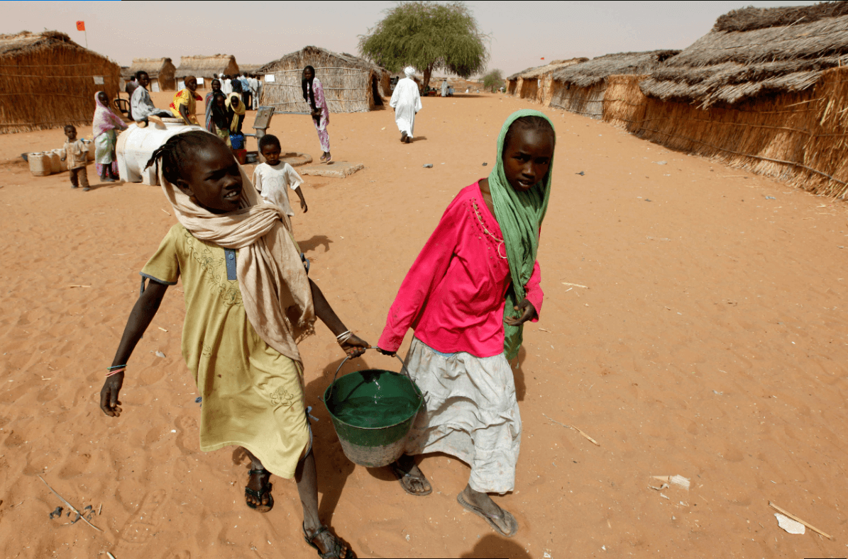 Dos ninas sudanesas cargan agua en un campo de refugiados