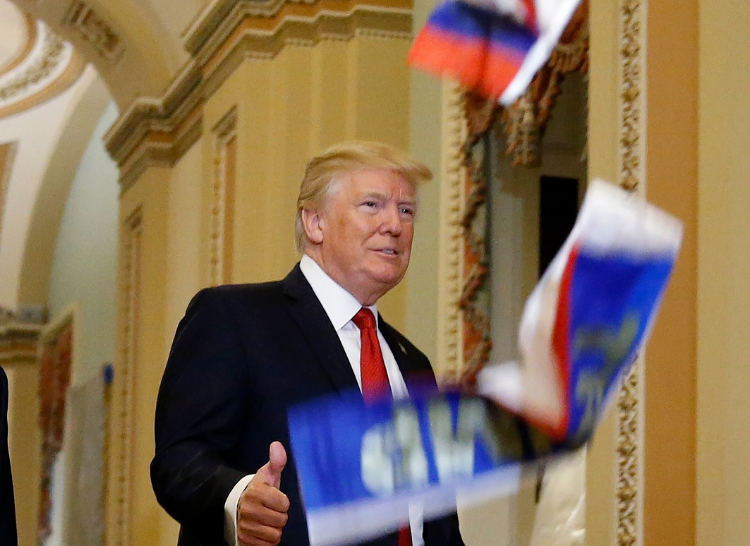 ‘Trump es un traidor!, gritan a mandatario y le arrojan banderas rusas