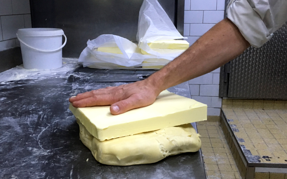 Pastelero francés sostiene una barra de mantequilla 