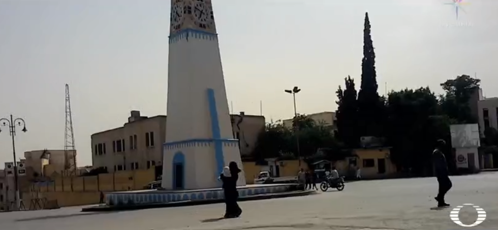 Torre en plaza de Raqqa; una mujer cubierta con una burka negra
