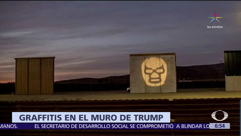 Activistas proyectan graffitis virtuales en prototipos del muro fronterizo de Trump