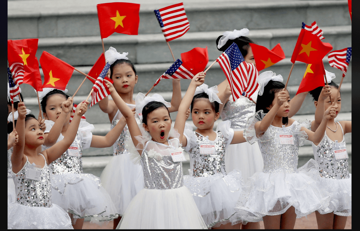 Niñas vietnamitas ondean banderas durante visita de Trump a Vietnam