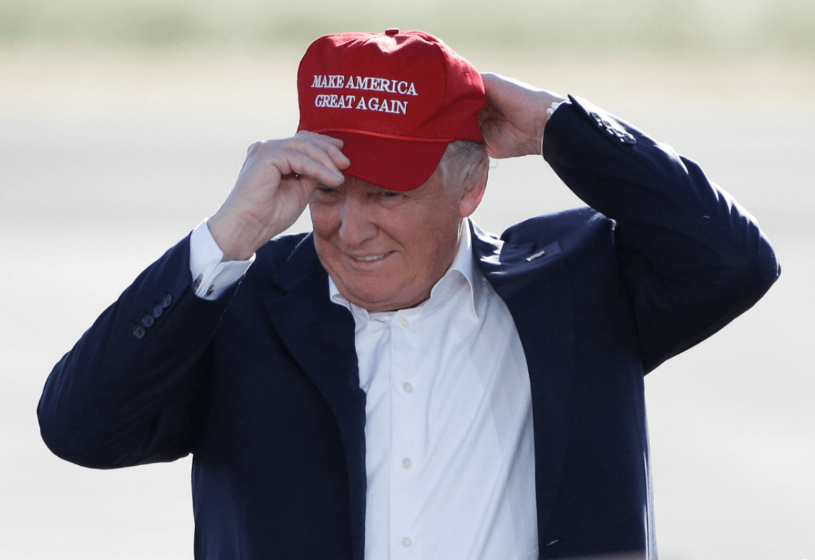 Trump usando una gorra con su lema de campana