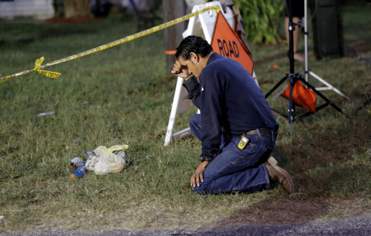 Un hombre se arodilla frente al lugar de la masacre en Texas