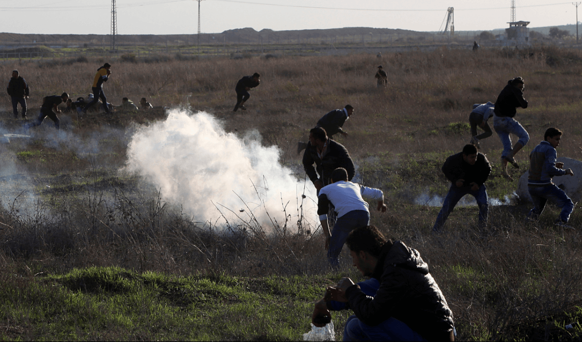 Palestinos corren ante el lanzamiento de gases lacrimógenos