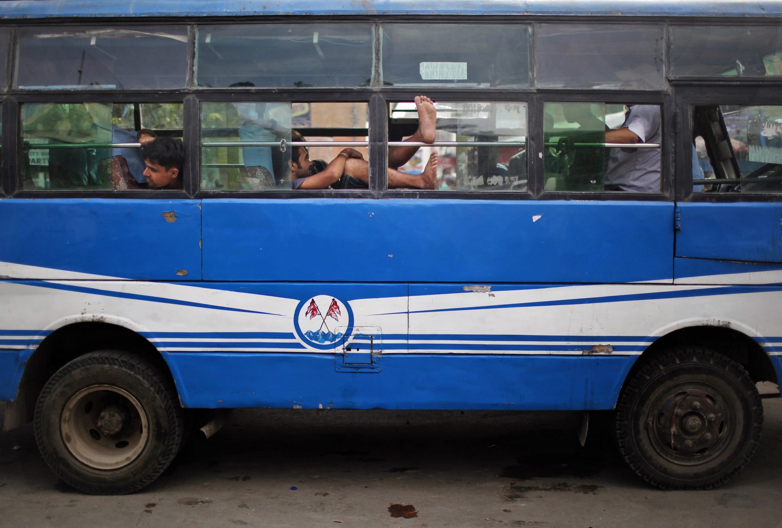 Pasajero con los pies de fuera en un autobús en India