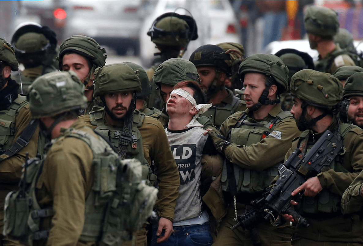 Soldados israelíes arrestan a un joven palestino herido