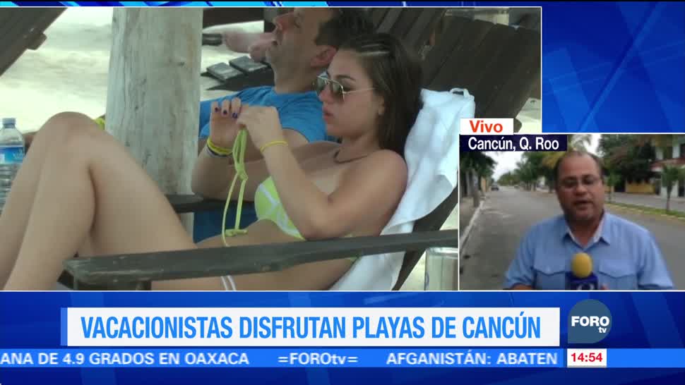 Turistas disfrutan las playas de Cancún