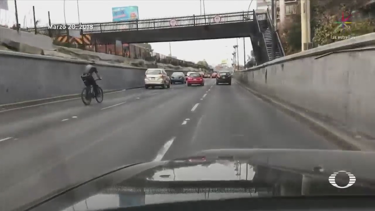 Ciclista sin casco circula en viaducto
