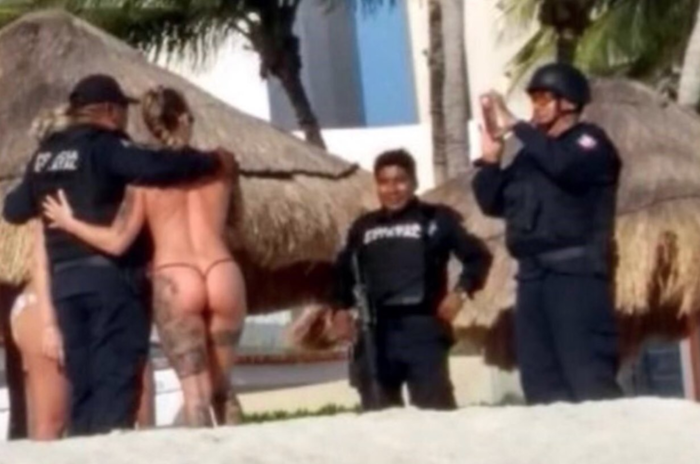 Policías de Cancún posan para fotos con turistas topless