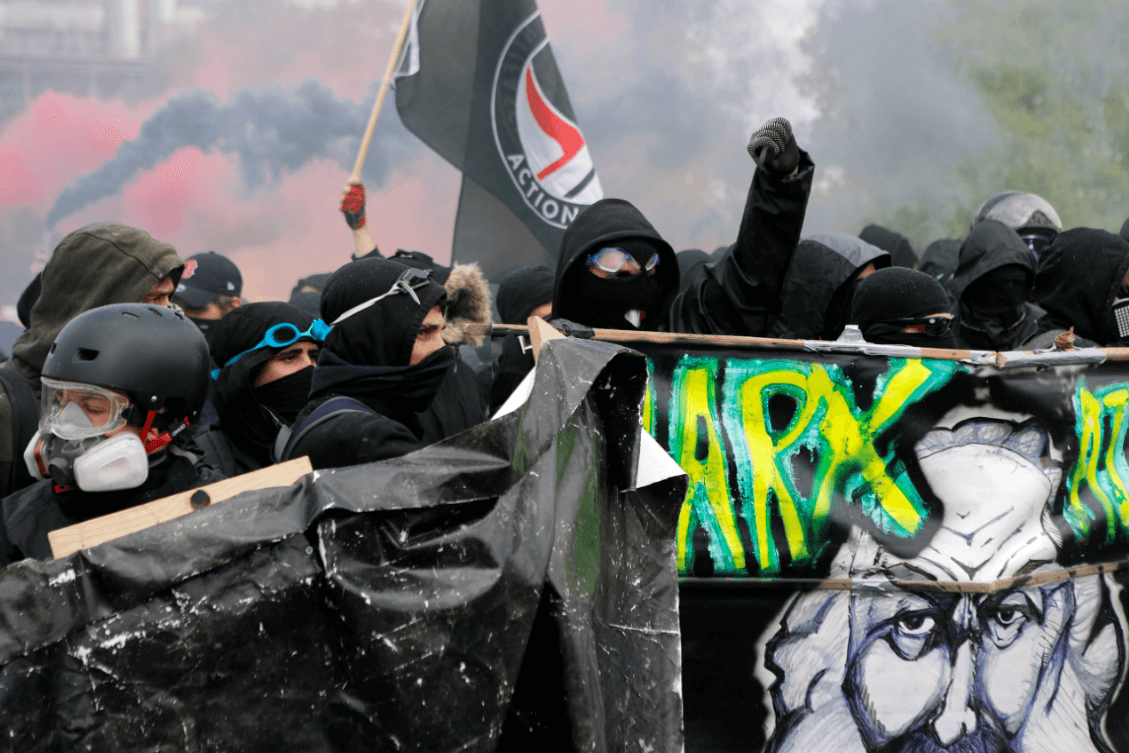Activistas en Francia portan mascarillas y una imagen de Karl Marx. (AP) 