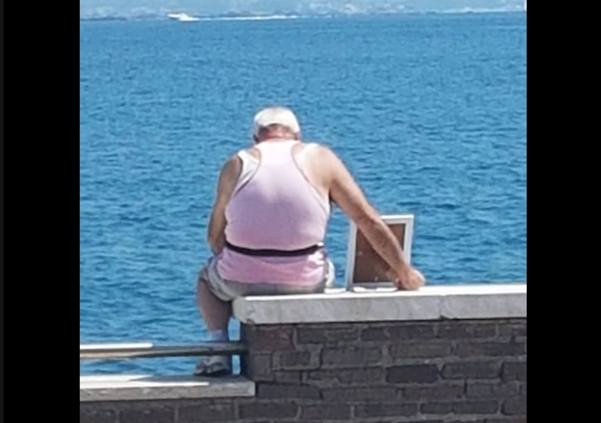 Esta es la historia del conmovedor anciano que lleva un retrato de su esposa al mar y cuya foto se hizo viral