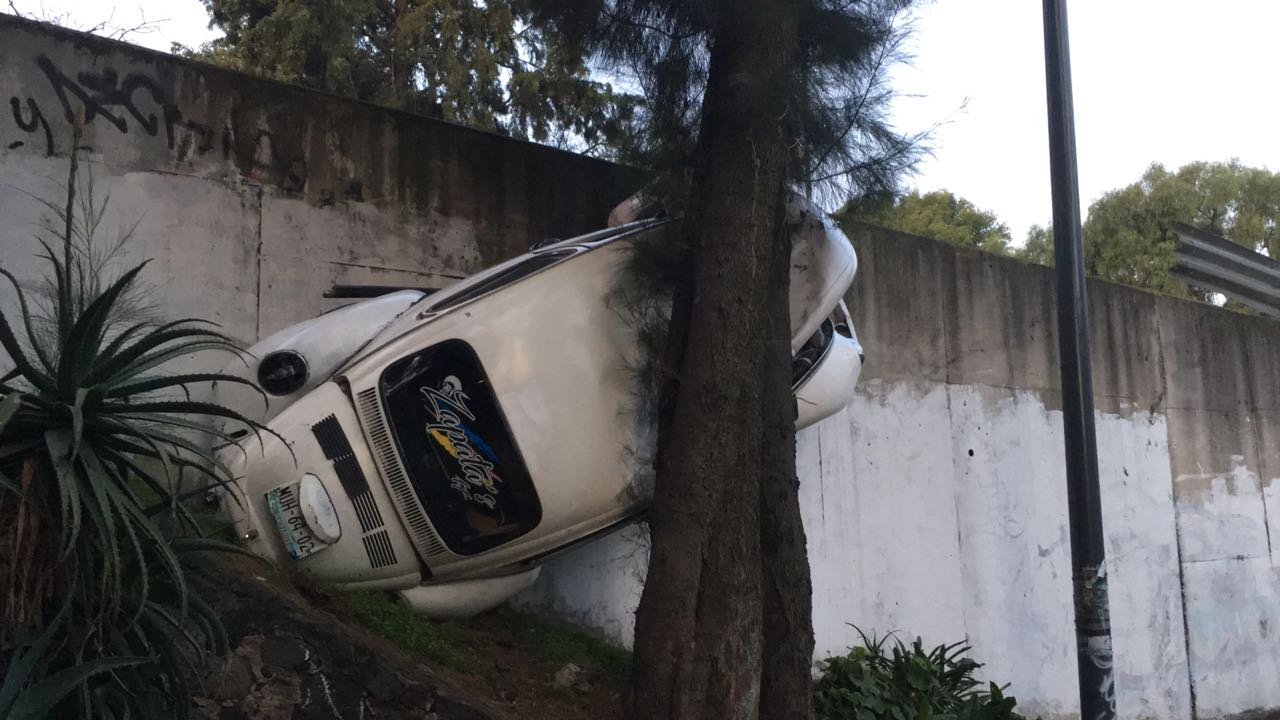 Auto se sale de carretera México Cuernavaca cae sobre árbol