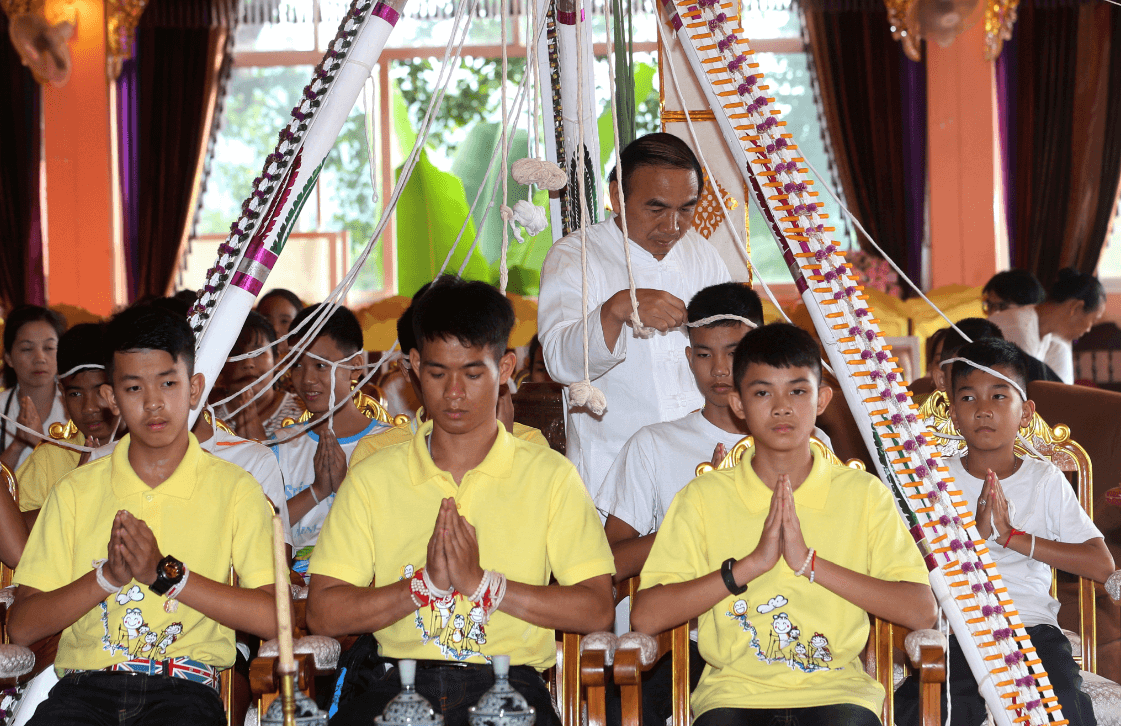 Niños rescatados en cueva tailandesa visitan templo