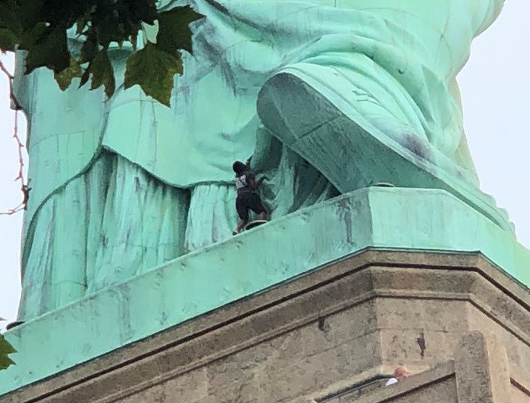 Mujer escala Estatua Libertad protesta migratoria Trump