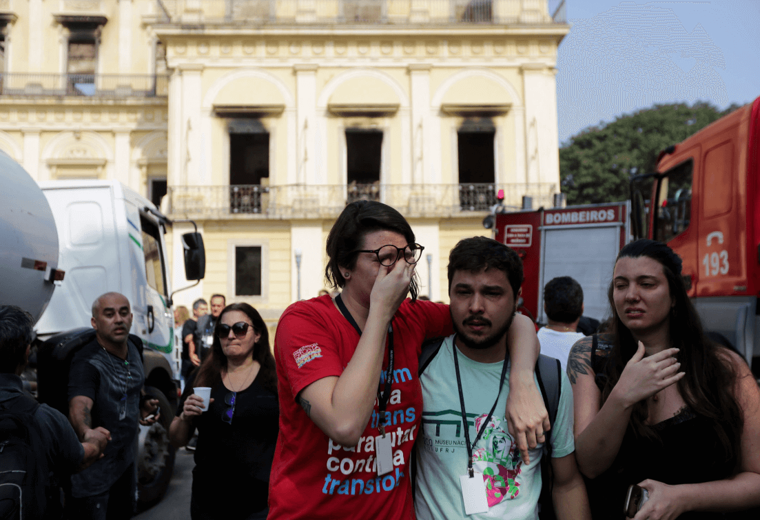 Funcionarios del Museo Nacional lloran tras el incendio en Río de Janeiro. (EFE) 