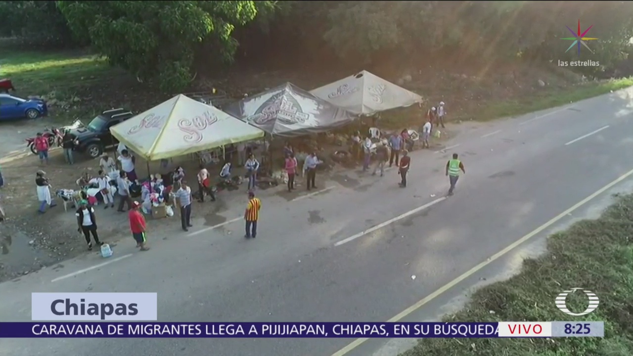 Chiapanecos reparten víveres a caravana migrante en carretera de Pijijiapan