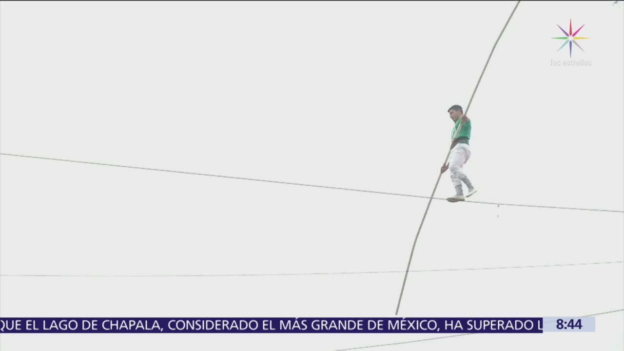 Equilibrista camina sobre cuerda floja entre dos edificios