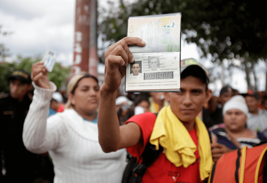Migrantes hondureños muestran su identificación en Guatemala. (AP) 