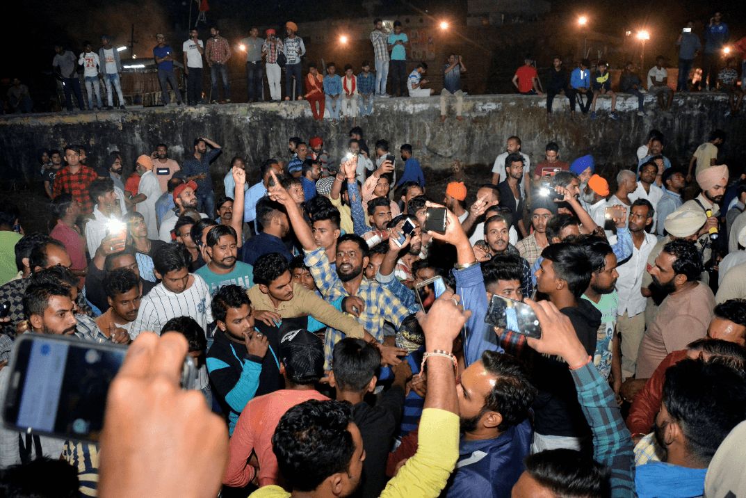 Una multitud grita consignas en el lugar del accidente de tren en la India. (AP) 