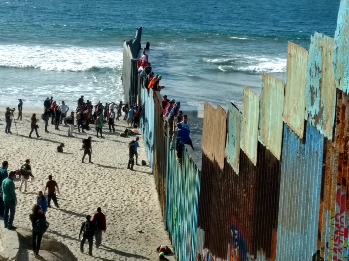 Caravana migrante se trepan a valla fronteriza en Tijuana