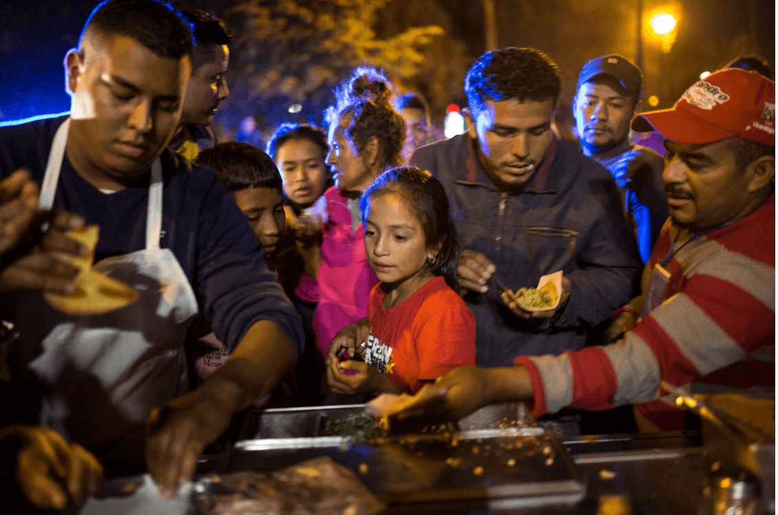 Migrantes centroamericanos reciben alimento en Mexicali. (AP) 