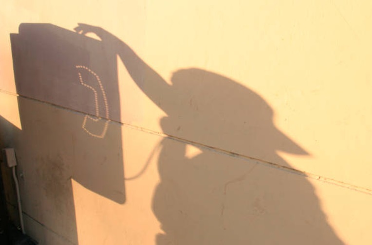 La sombra de una persona que llama usando un teléfono público, 26 de enero 2019, (Getty Images)