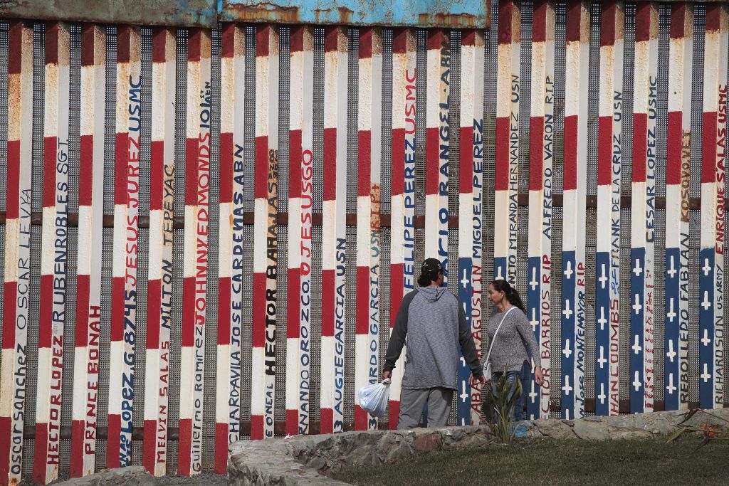 Foto: Dos personas caminan a lado de la valla fronteriza entre Tijuana y San Diego el 28 de enero del 2019