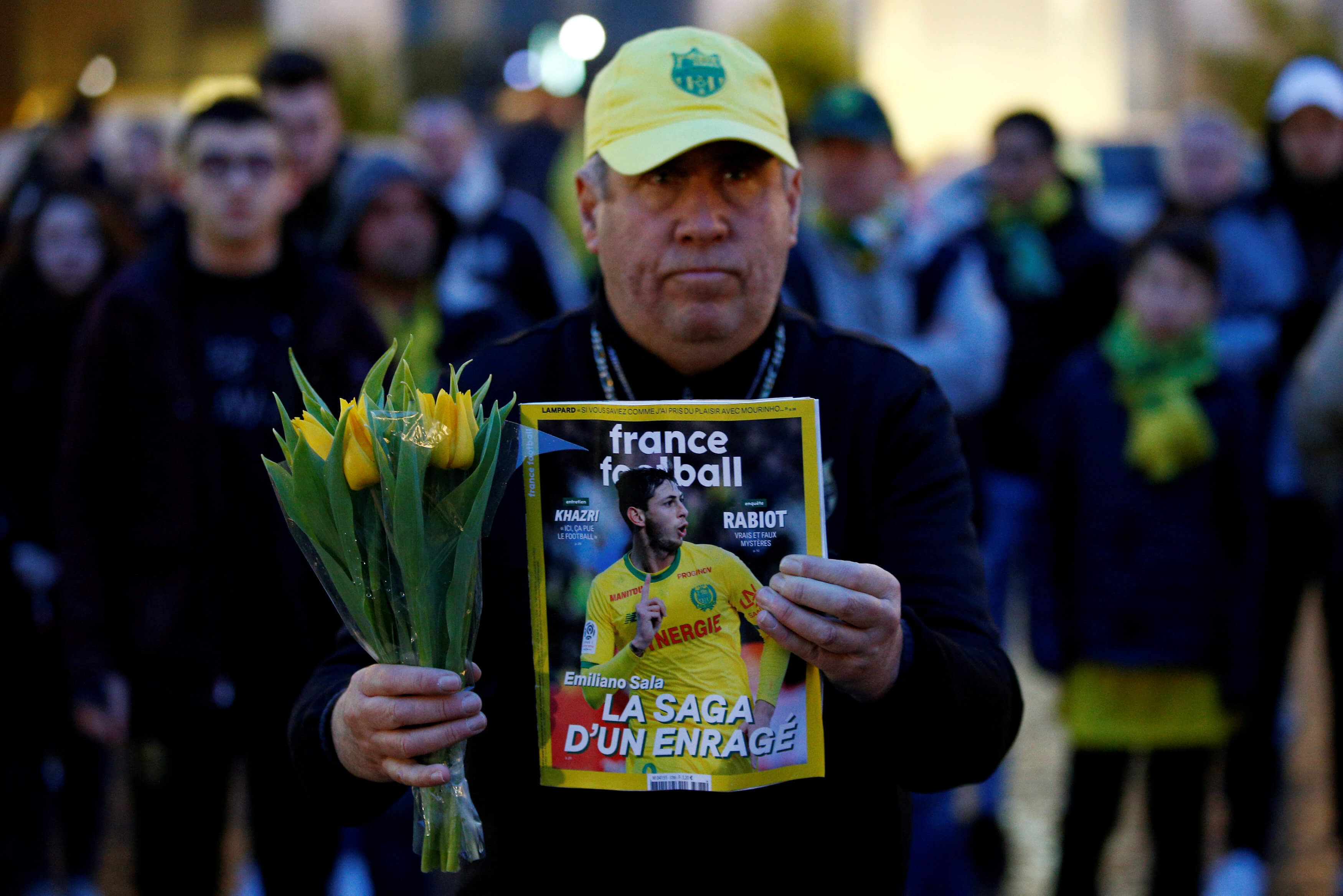 Foto: Seguidor del Nantes sostiene un ramo de flores y una revista con la imagen del futbolista argentino Emiliano Sala