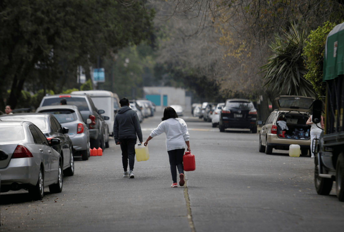 Personas cargan bidones con gasolina en México. (Reuters)