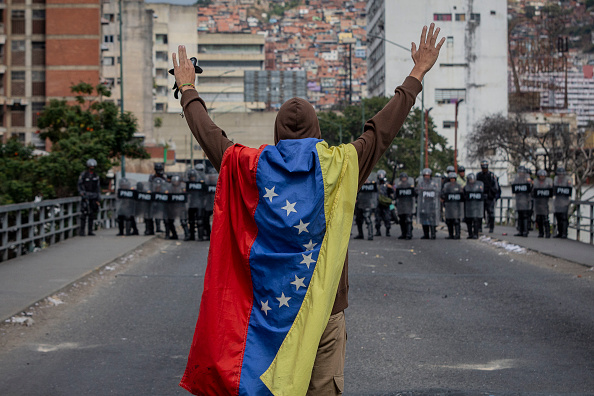 Foto: hombre envuelto en una bandera en Caracas, 23 de enero 2019