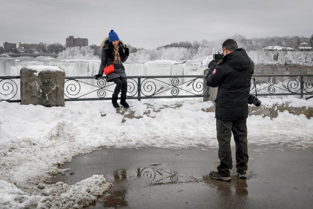 Una pareja toma una fotografía de las cataratas del Niágara el 22 de enero de 2018 (Reuters)
