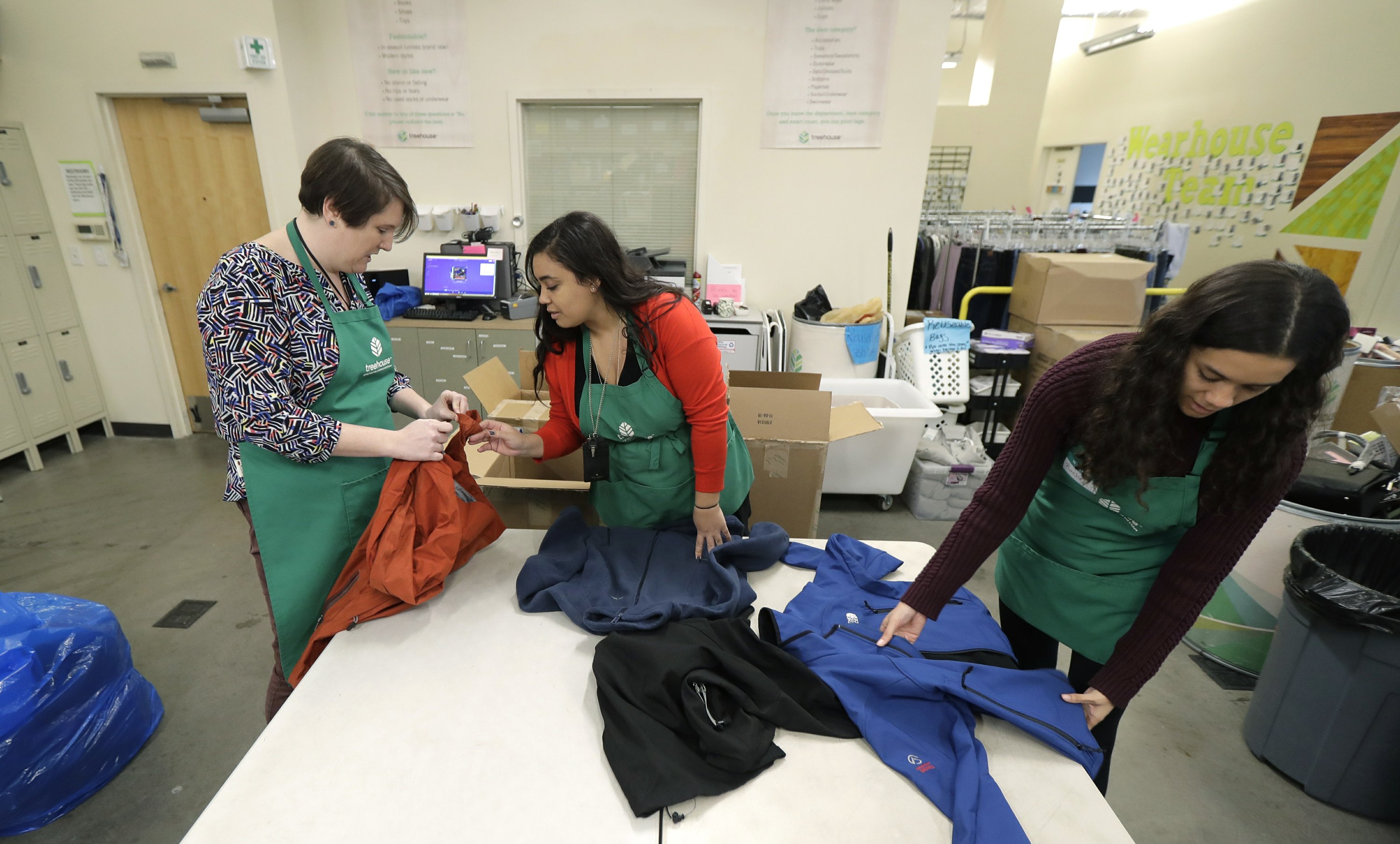 Voluntarias y trabajadoras de la asociación 'Treehouse' ordenan una donación de ropa realizada durante diciembre del 2018 (AP Images)