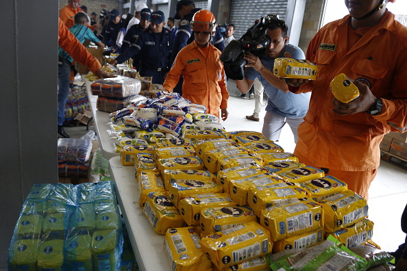 Foto: Miembros de la brigada de bomberos en Colombia acomodan en paquetes de ayuda humanitaria que se serán enviados a Vezuela, 14 febrero 2019