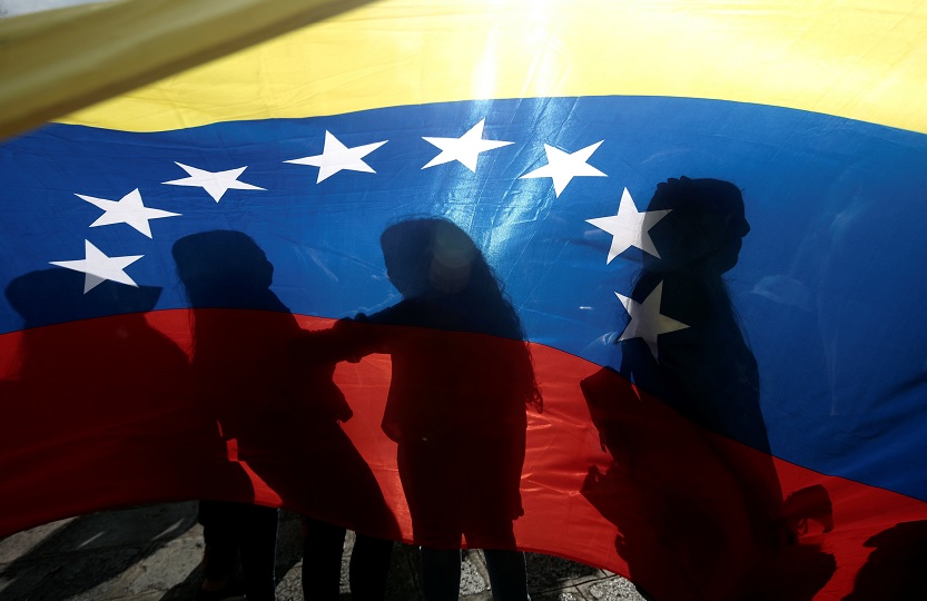 Foto: Venezolanos proyectan sombras sobre una bandera durante un mitin en apoyo al líder opositor Juan Guaidó, Venezuela, febrero 2 de 2019 (Reuters)