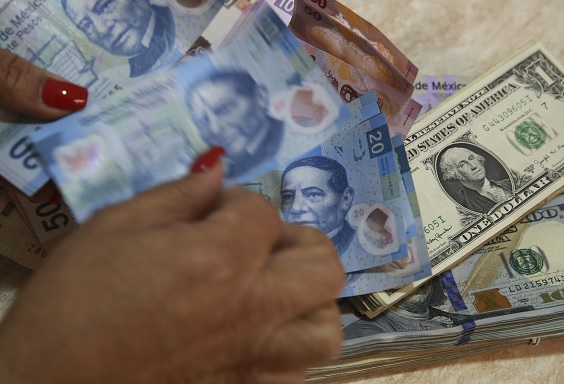 Foto: Un empleado de banco cuenta los billetes en pesos mexicanos además de los billetes en dólares estadounidenses en la Ciudad de México, México, febrero 5 de 2019 (Getty Images)