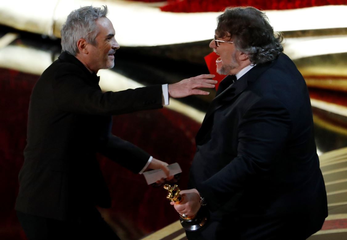 Foto: Guillermo del Toro (der) entrega a Alfonso Cuarón (der) el Oscar como mejor director, el 24 de febrero de 2019 (Reuters)