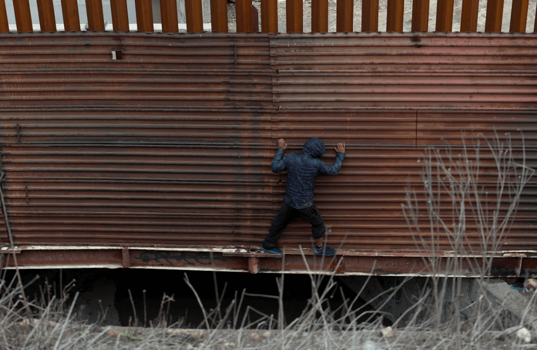 Foto: Un migrante centroamericano intenta cruzar la valla fronteriza en Tijuana, 6 diciembre 2018, México