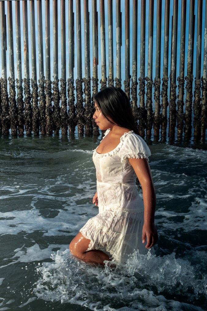 Yalitza Aparicio aparece frente a una porción del cerco fronterizo entre Tijuana y San Ysidro que prolonga hasta las aguas poco profundas (W Magazine)